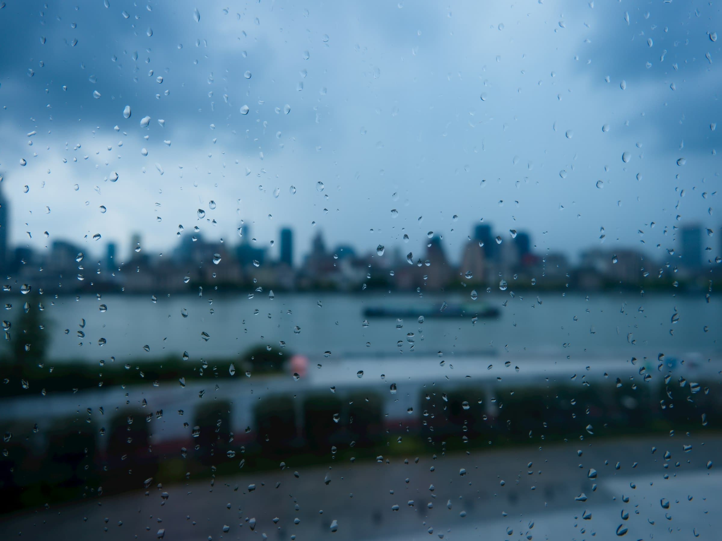 Rain streaks down a window overlooking the Pudong skyline in Shanghai
